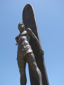 Surfer statue on West Cliff Dr., Santa Cruz against clear blue sky